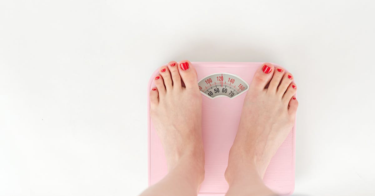 Which mod showed me my tool's durability? - Top view of crop anonymous barefoot female measuring weight on scales on white background