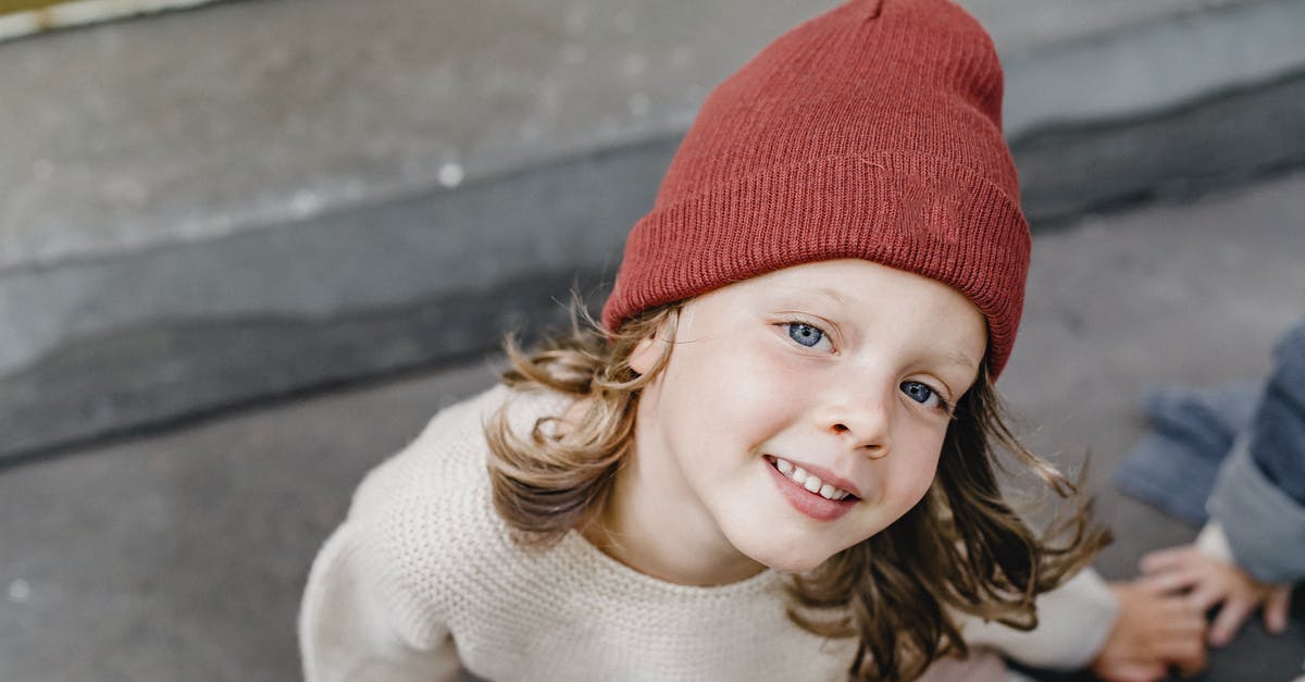 Which outfit should I use for vault entrance guards? - From above of cheerful girl in hat looking at camera while sitting on doorstep with anonymous kid on blurred background
