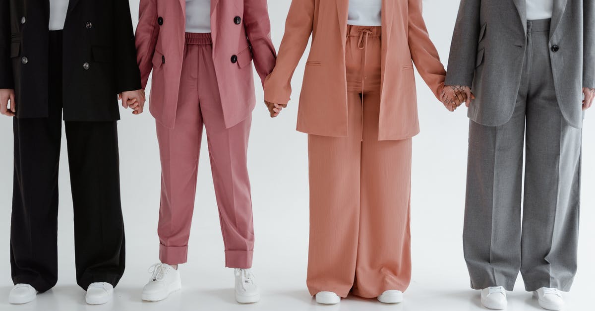 Which Outfits should I buy? - People Wearing Blazers and Pants Holding Hands while Standing Together