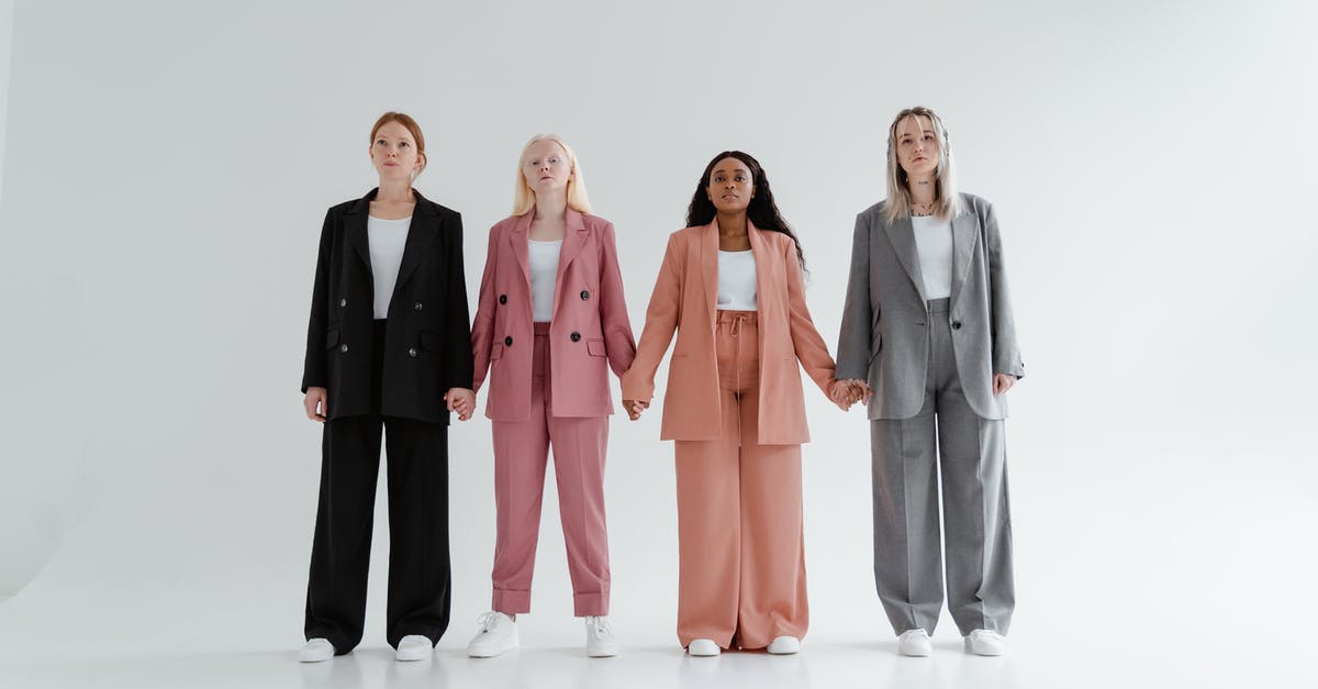 Which Outfits should I buy? - Women in Blazer and Pants Standing while Holding Hands