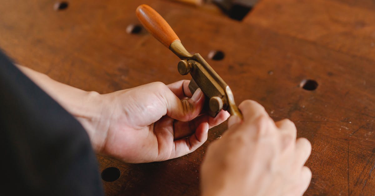 Which pieces of equipment have special uses (e.g. as crafting components)? - From above of male artisan with special metal spokeshave in hands standing at wooden workbench during work in professional studio
