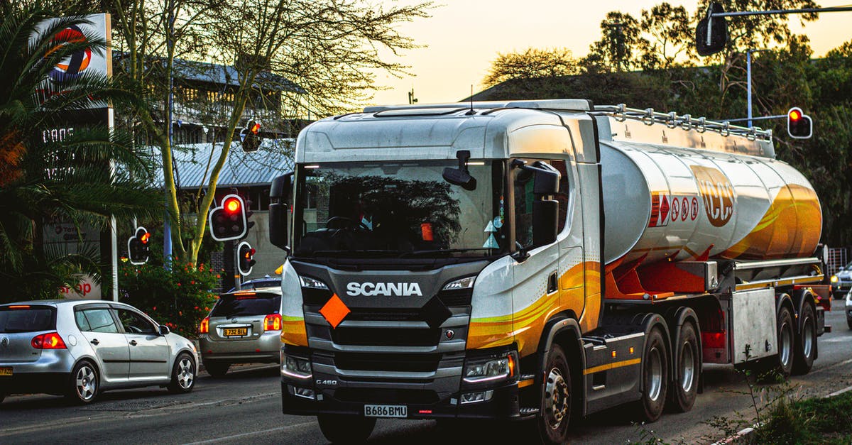 Which vehicle has the lowest fuel consumption? - White and Orange Truck on Road