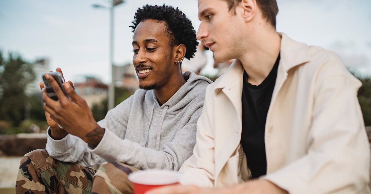 Which WoW class/spec has the best mobility for questing and solo'ing low level dungeons - Cheerful black man showing video on mobile phone to friend