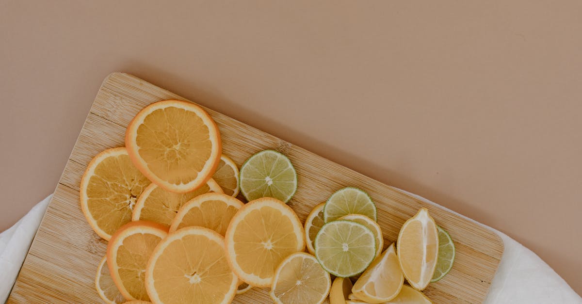 While in workshop mode, what is the difference between green and yellow highlighted items? - Top view of sliced with yellow lemons near oranges and green limes on wooden cutting board on white napkin on beige surface in light place