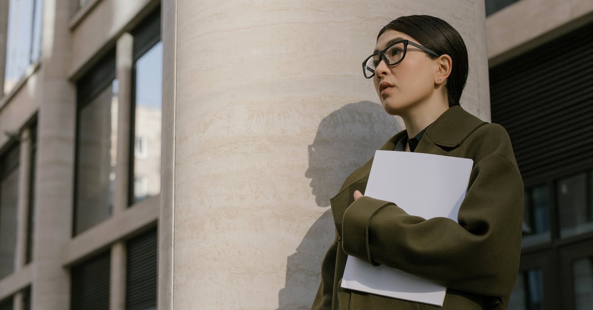 Who Are The Highest Potential Players On Career Mode? - Woman in Black Framed Eyeglasses and Green Coat Near the Wall