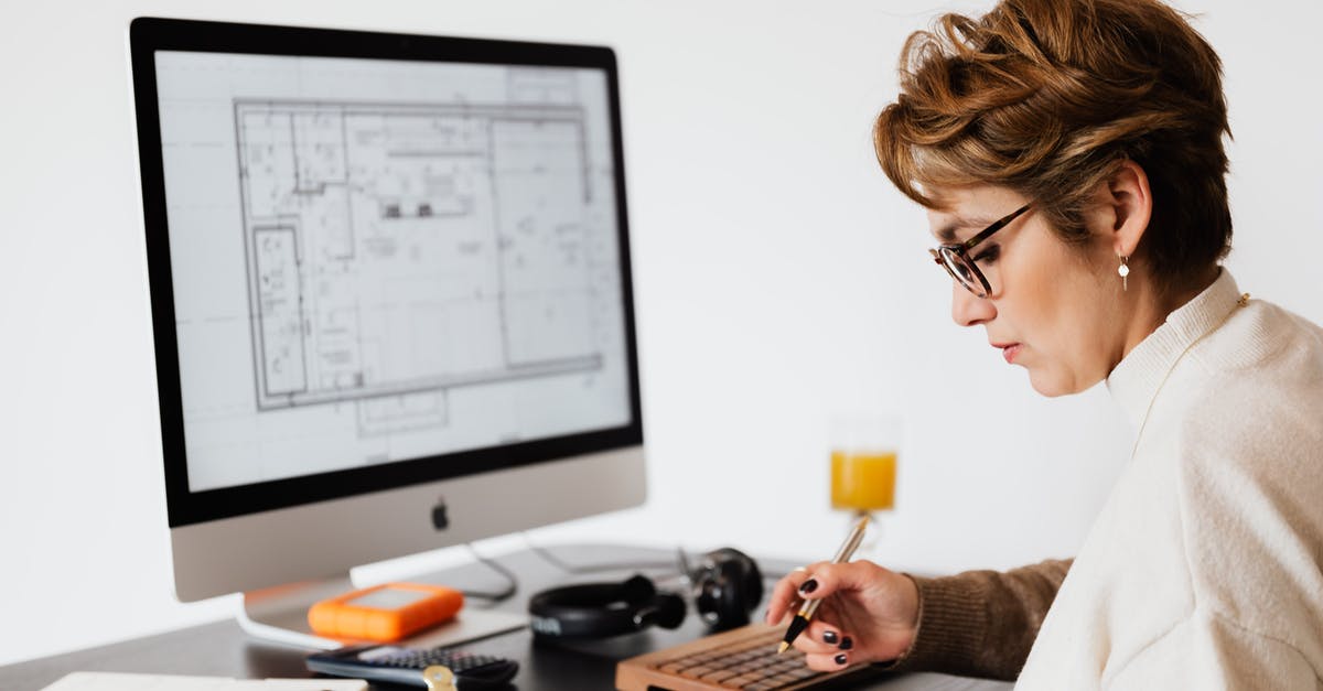 Who does the Monitor think the Master Chief is? - Focused woman editing paper documents during work at desk with computer Who does the Monitor think the Master Chief is? - Focused woman editing paper documents during work at desk with computer