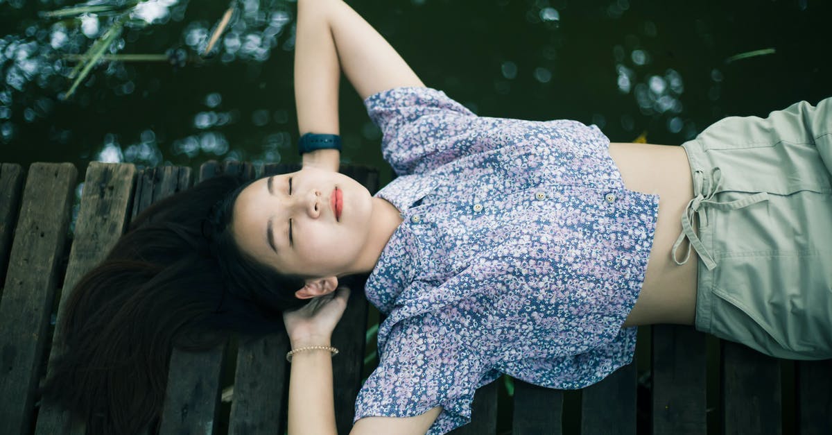 Who has the biggest head? - Woman in Blue and White Floral Dress Lying on Brown Wooden Bench Who has the biggest head? - Woman in Blue and White Floral Dress Lying on Brown Wooden Bench