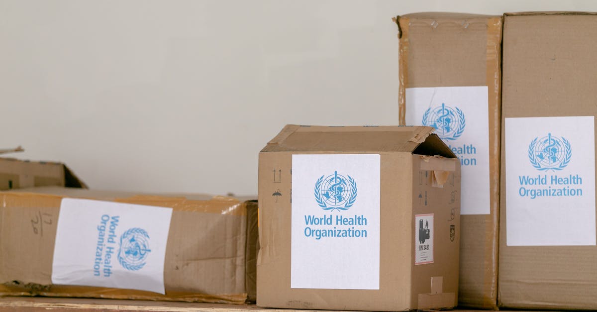 Who should be invited to which movie? - Blue emblem sticker of World Health Organization on carton boxes heaped on table