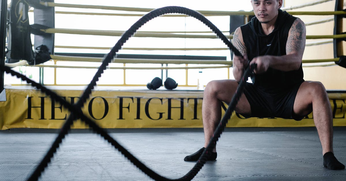 Who to battle when first able to access gyms? - Determined Latin American man exercising with ropes Who to battle when first able to access gyms? - Determined Latin American man exercising with ropes