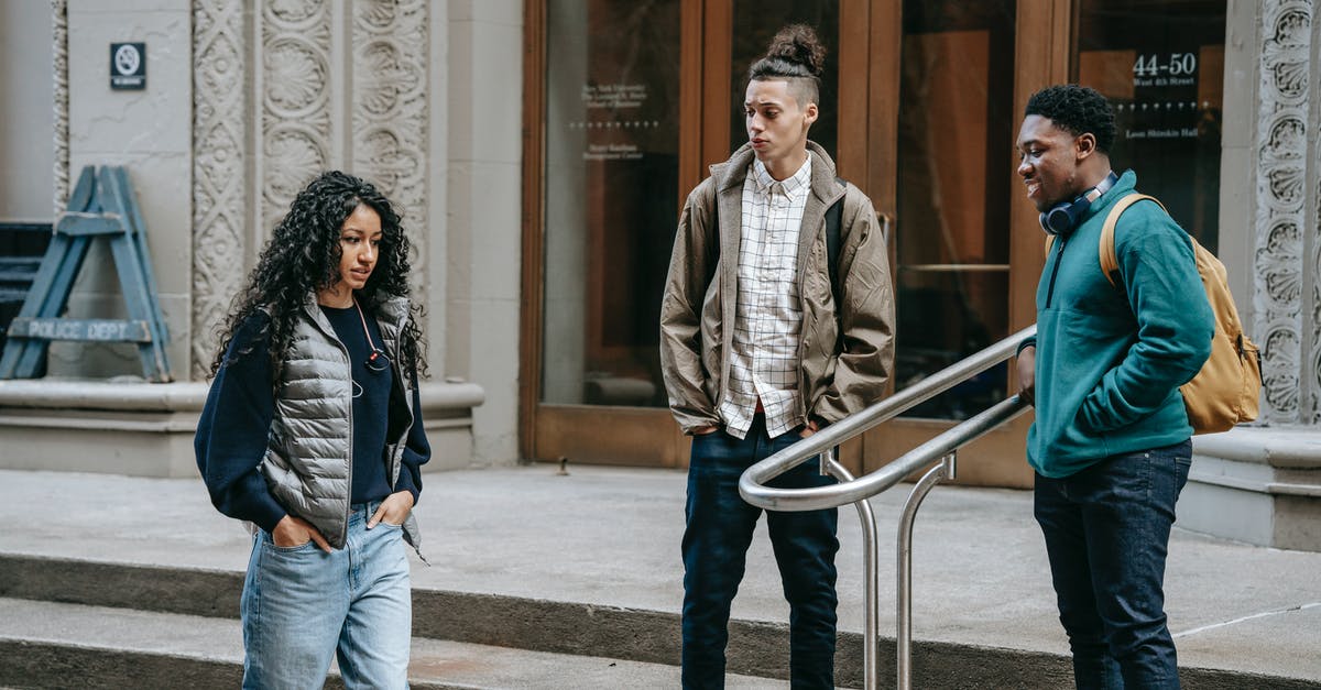 Whoa, A Bad Relationship - Young ethnic outcast female walking on street near diverse bullying male classmates standing on building stairs and smiling Whoa, A Bad Relationship - Young ethnic outcast female walking on street near diverse bullying male classmates standing on building stairs and smiling