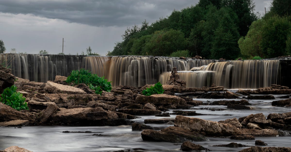 Whoa! How did the water not go flowing everywhere? - Waterfalls Near Green Trees Under White Clouds