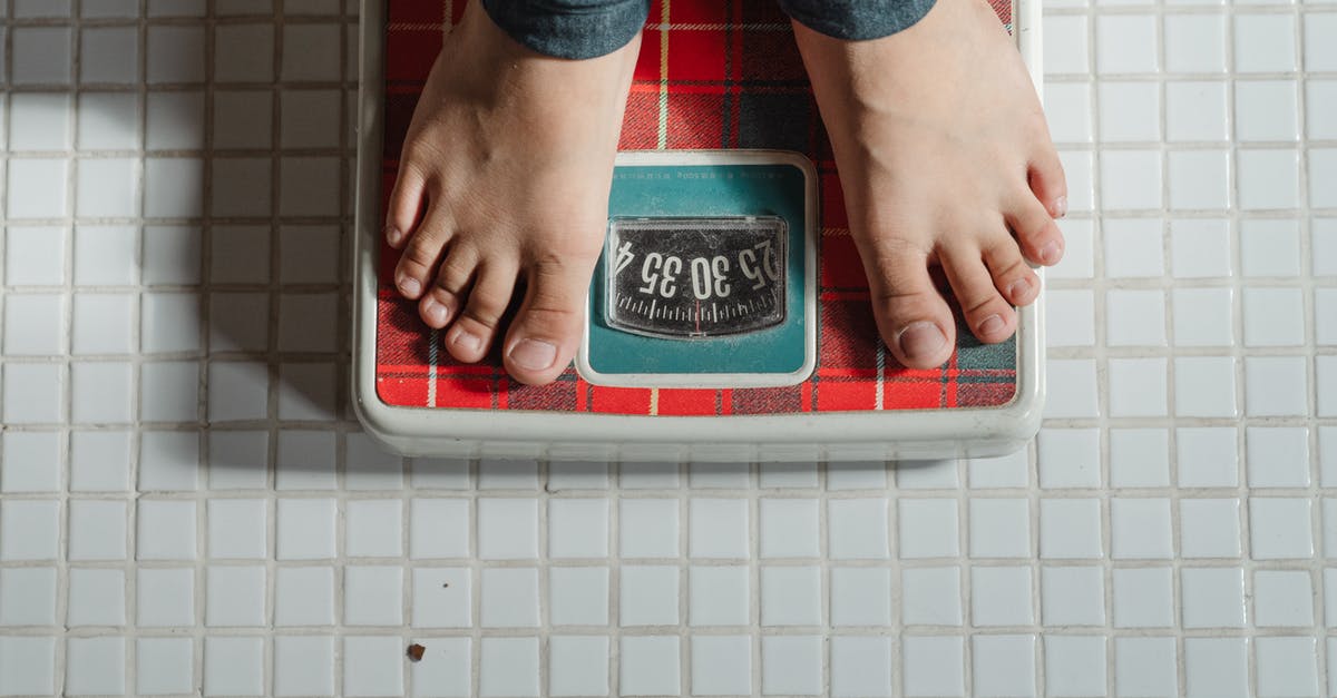 Why am I suddenly seeing this instead of normal inventory? - From above crop anonymous barefoot child in jeans standing on weigh scales on tiled floor of bathroom
