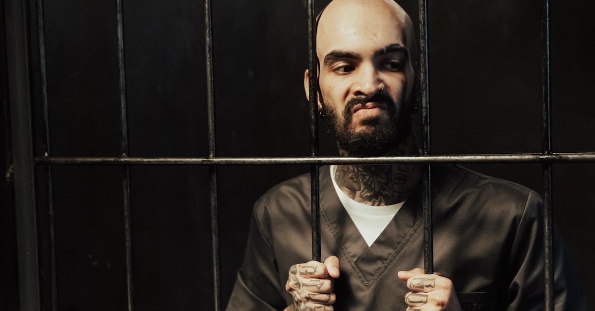 Why are many of my prisoners staying in their holding cell? [duplicate] - Man in Brown Coat Standing Beside Black Metal Gate
