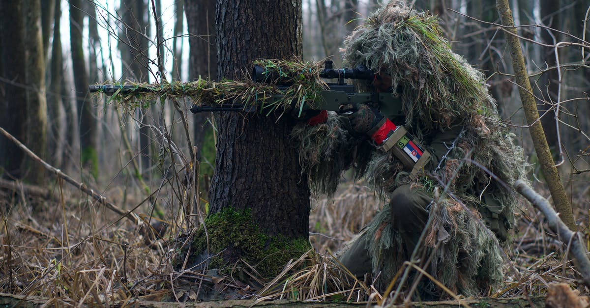 Why are my sniper rifles overheating in Mass Effect? - A Soldier Sniper Aiming Though The Rifle Scope In Forest Why are my sniper rifles overheating in Mass Effect? - A Soldier Sniper Aiming Though The Rifle Scope In Forest