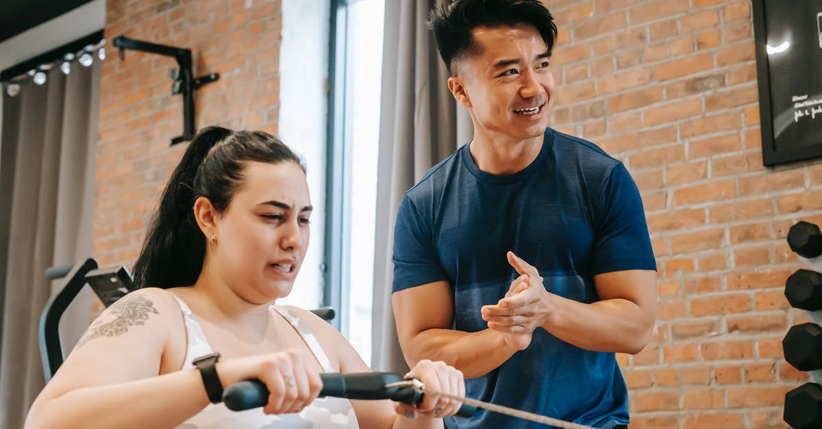 Why are some low CP pokemon hard to capture? - Low angle of smiling ethnic male trainer clapping hands to overweight female training on rowing machine in gym Why are some low CP pokemon hard to capture? - Low angle of smiling ethnic male trainer clapping hands to overweight female training on rowing machine in gym