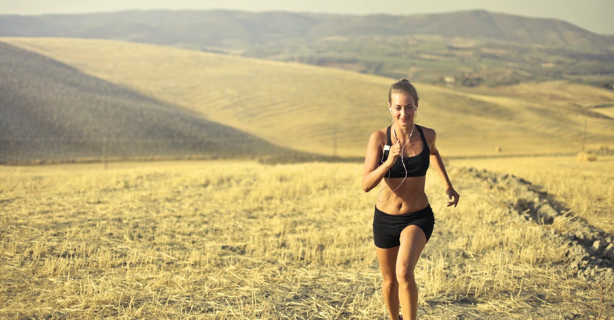 Why aren't trains using all the available stops? - Powerful young female athlete in activewear running along hill on background of mountainous landscape and listening to music in earphones during cardio training