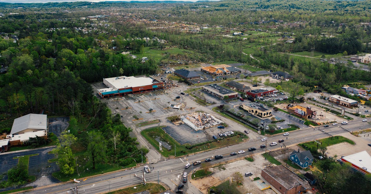 Why build a large spaceship when a small one will do? - Aerial view of small town outpost area with low level commerce buildings surrounded with lush green trees