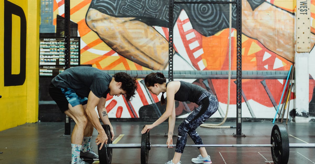 Why can't I add Pokemon into a Gym? - A Man and a Woman Adding a Plate on a Barbell