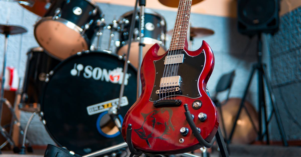 Why can't I beat Hypothermia? - From below of modern electronic shiny guitar against drum kit and speakers in music studio