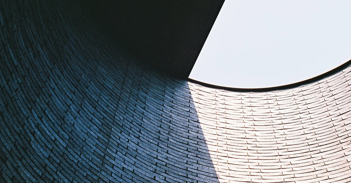 Why can't I build anything on these tiles? - From below of modern stone building with rounded tiled wall and half opened roof against cloudless sky in sunlight in daytime