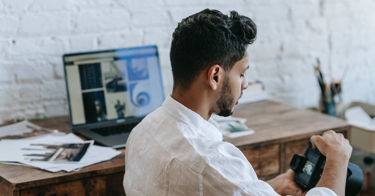 Why can't I edit or create my sim? - Attentive ethnic man using photo camera in light room Why can't I edit or create my sim? - Attentive ethnic man using photo camera in light room