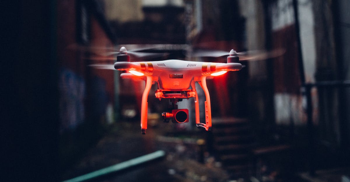 Why can't I power up my drone system? - Red glowing modern drone flying in air on blurred background of gloomy industrial street Why can't I power up my drone system? - Red glowing modern drone flying in air on blurred background of gloomy industrial street