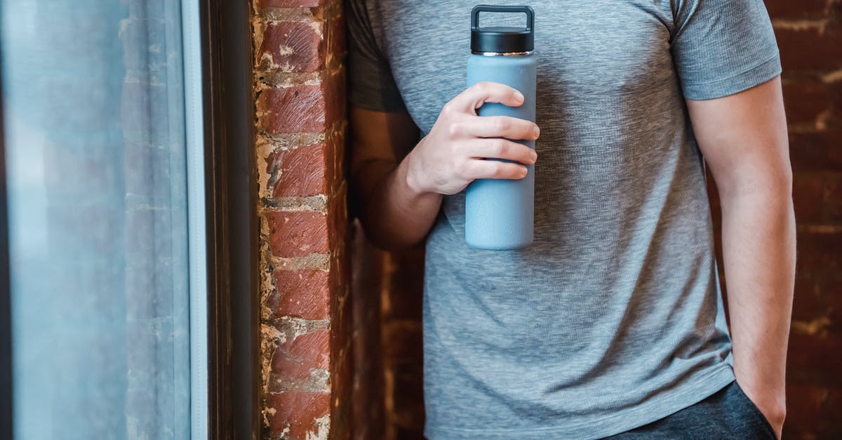 Why can't I see any gym or pokestop - Unrecognizable muscular male in sportswear standing with hand in pocket near brick wall and window with bottle in hand in gym