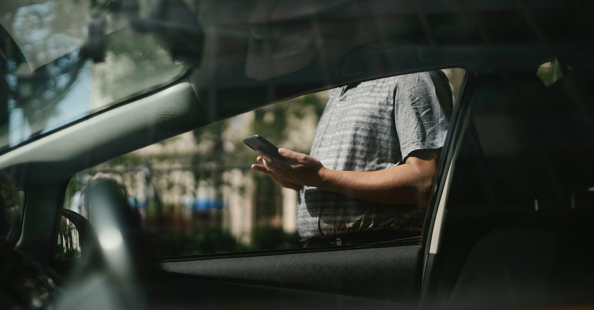 Why can't I send messages to my friends? - Man using smartphone near taxi car