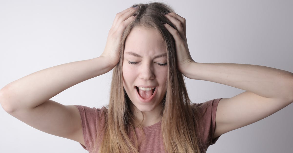 Why can't I shout at the graybeards? - Angry crazy female in casual pink t shirt touching head while being unhappy and shouting loudly against gray wall background