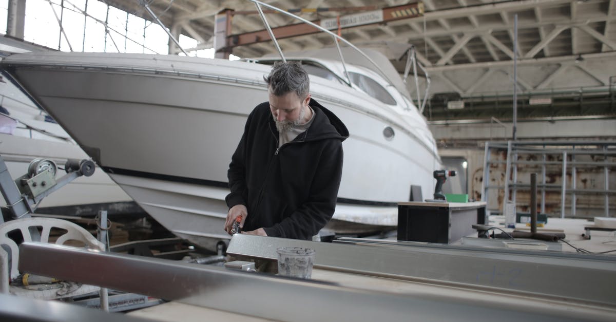 Why can't I use a Robot Workbench at Boston Airport Ruins? - Concentrated bearded adult workman in casual wear working with metal detail near boat in garage