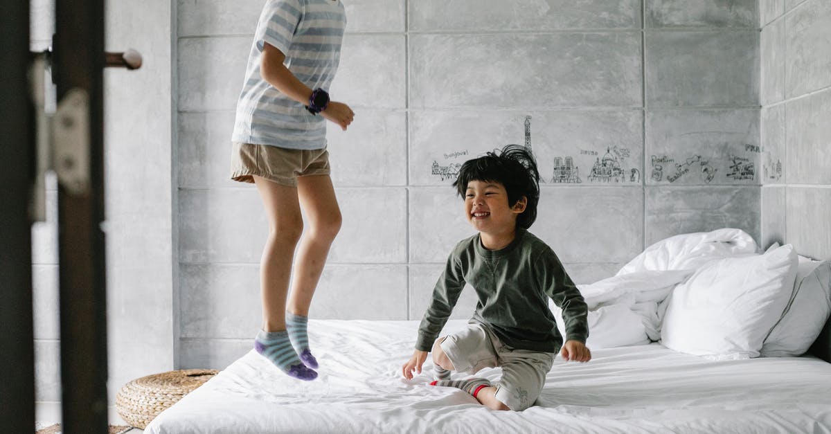 Why can't my brother play the games I bought on my account? - Happy ethnic kids having fun on bed
