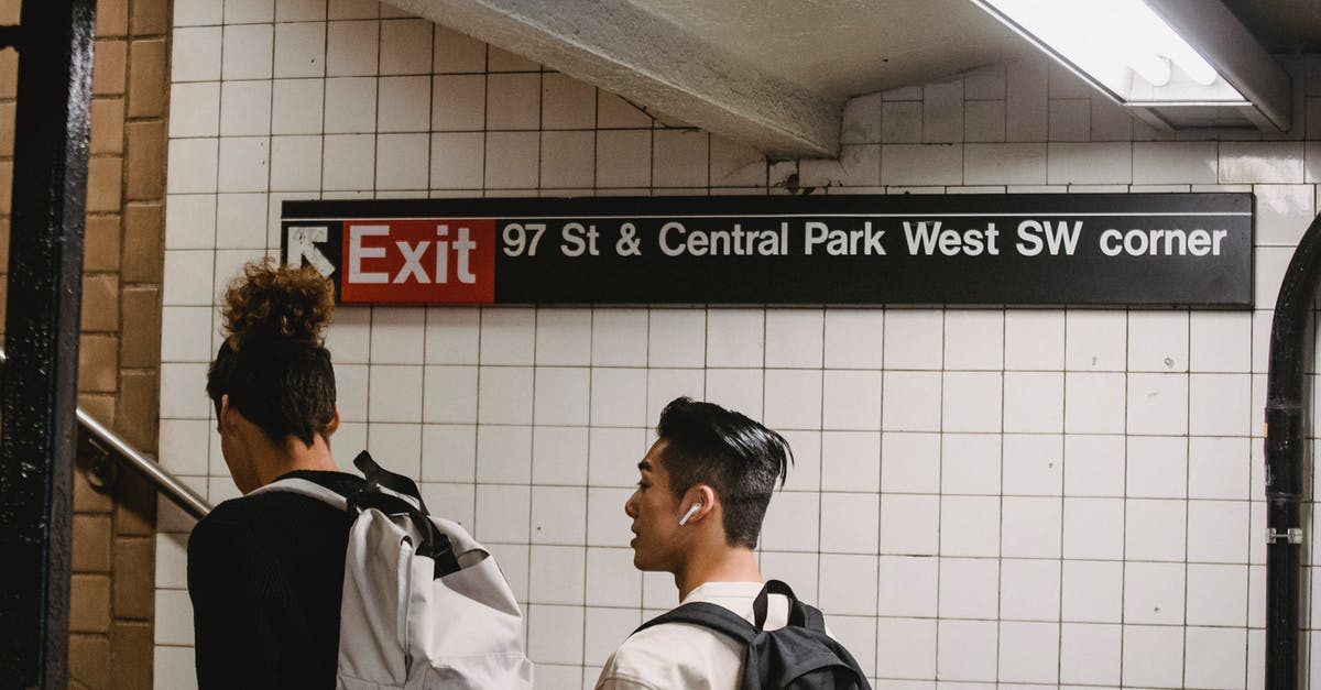 Why did my train choose the blocked path at the junction? - Back view of ethnic male walking in subway station with friend while commuting to university Why did my train choose the blocked path at the junction? - Back view of ethnic male walking in subway station with friend while commuting to university