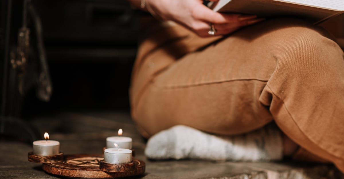 Why did the thieves guild believe Mercer Frey? - Unrecognizable mysterious female with book sitting in aged house near small burning candles placed on metal surface with spiritual symbol