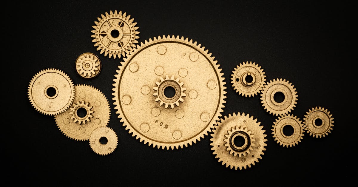 Why didn't this Gold machine lifeform die? - Photo of Golden Cogwheel on Black Background