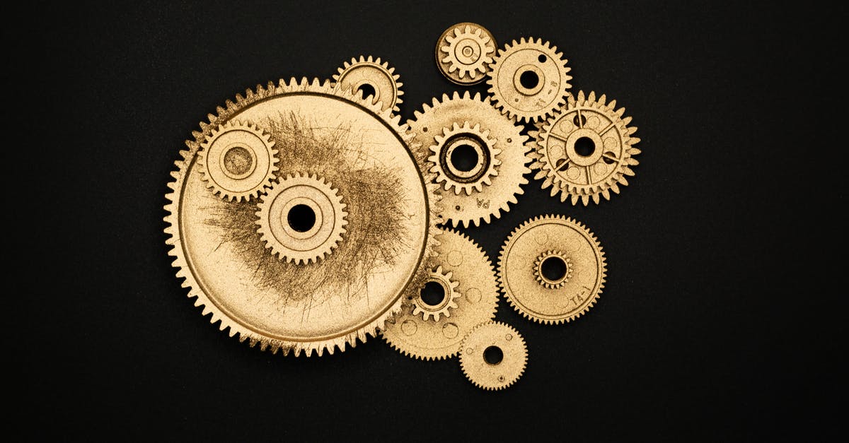 Why didn't this Gold machine lifeform die? - Photo of Golden Cogwheel on Black Background