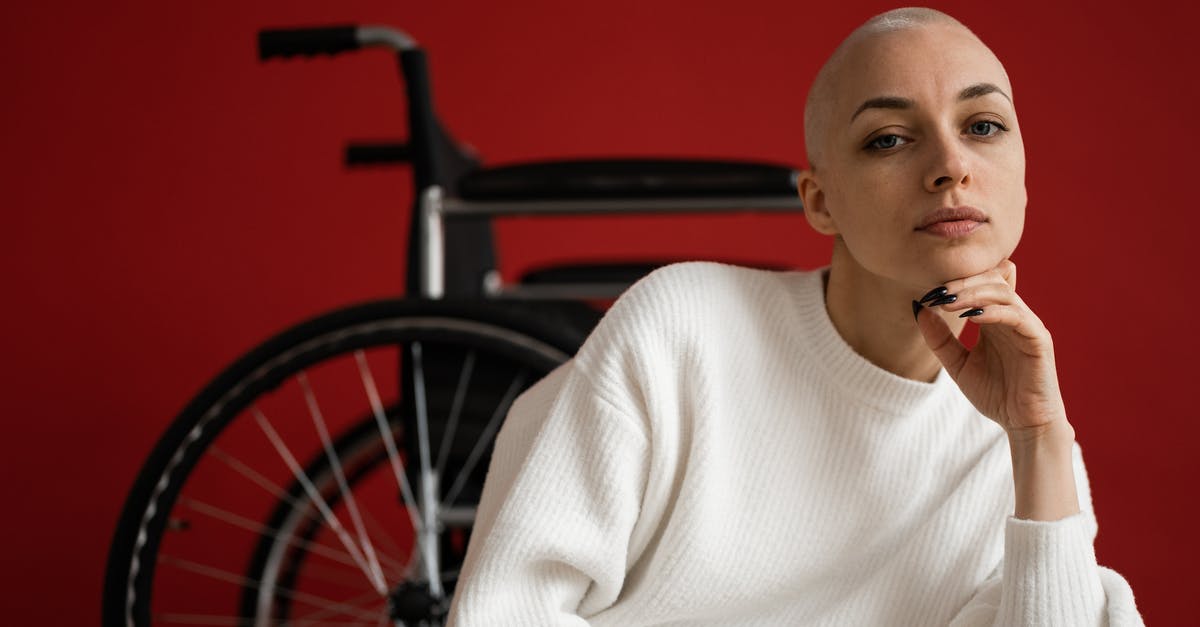 Why disable powerups? - Woman with shaved head against wheelchair on red background