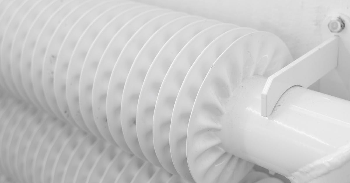 Why do games install existing components each time I install a game? - White metal tubed radiator system with pipe for industrial heating mounted to wall with hook in light room at home