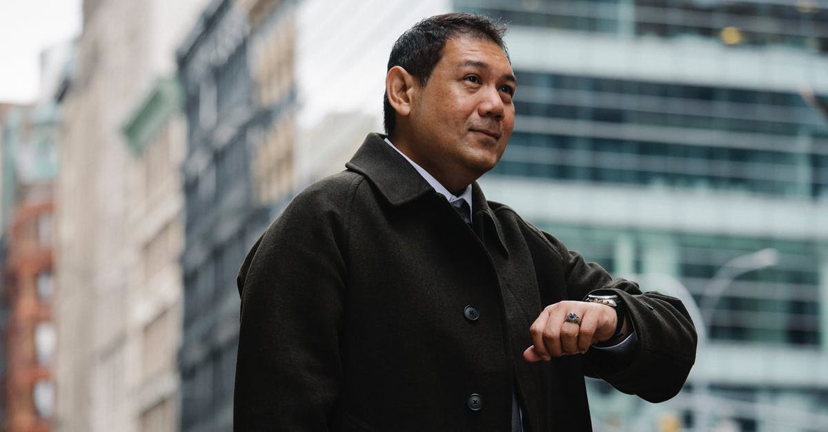 Why do I sometimes experience a delay despite a very low ping? - Elegant ethnic businessman checking time on wristwatch on city street