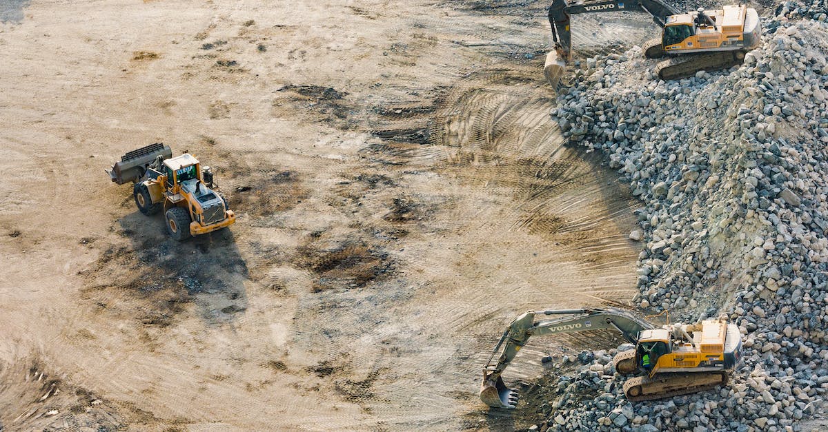 Why do mobs die in mined quarry? - Three Yellow Excavators Near Front End Loader