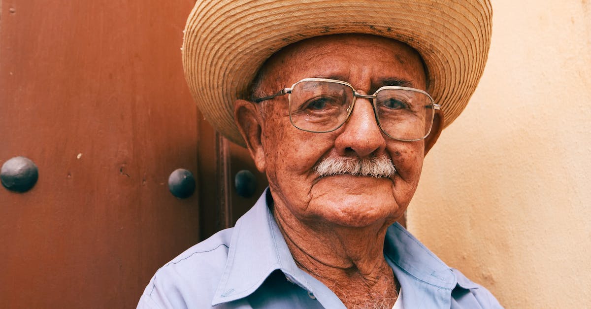 Why do people turn and face the bomb? - Close Up Photo of an Elderly Man Wearing a Straw Hat