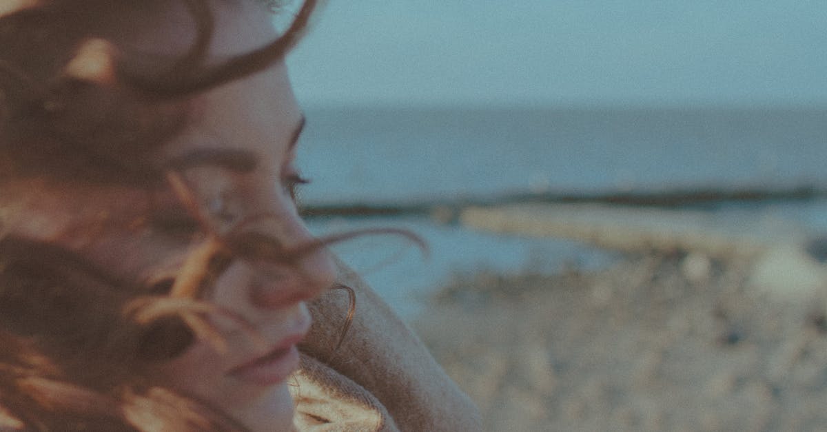 Why do people turn and face the bomb? - Woman in White Hoodie Standing on Beach Shore