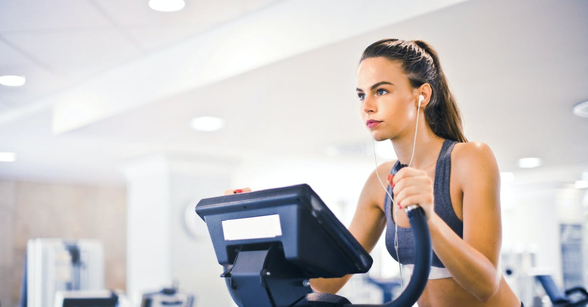 Why do some figure spaces have darker outlines? - Serious fit woman in earphones and activewear listening to music and running on treadmill in light contemporary sports center