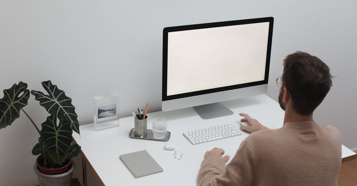 Why does /gamerule KeepInventory true not work? [duplicate] - Back view of anonymous male in sweater sitting at table with notepad and earbuds while browsing computer
