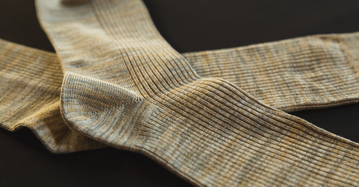 Why does it take so long to get an item? - From above of pair socks made of soft material placed above each other on black background Why does it take so long to get an item? - From above of pair socks made of soft material placed above each other on black background