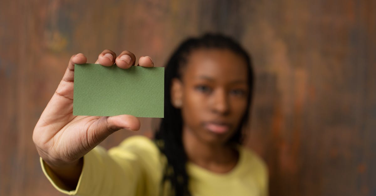 Why does my 3DS claim I have no space on my 4GB SD card while it looks empty? - Soft focus of African American female looking at camera and demonstrating green mock up business card in hand while standing near wooden wall