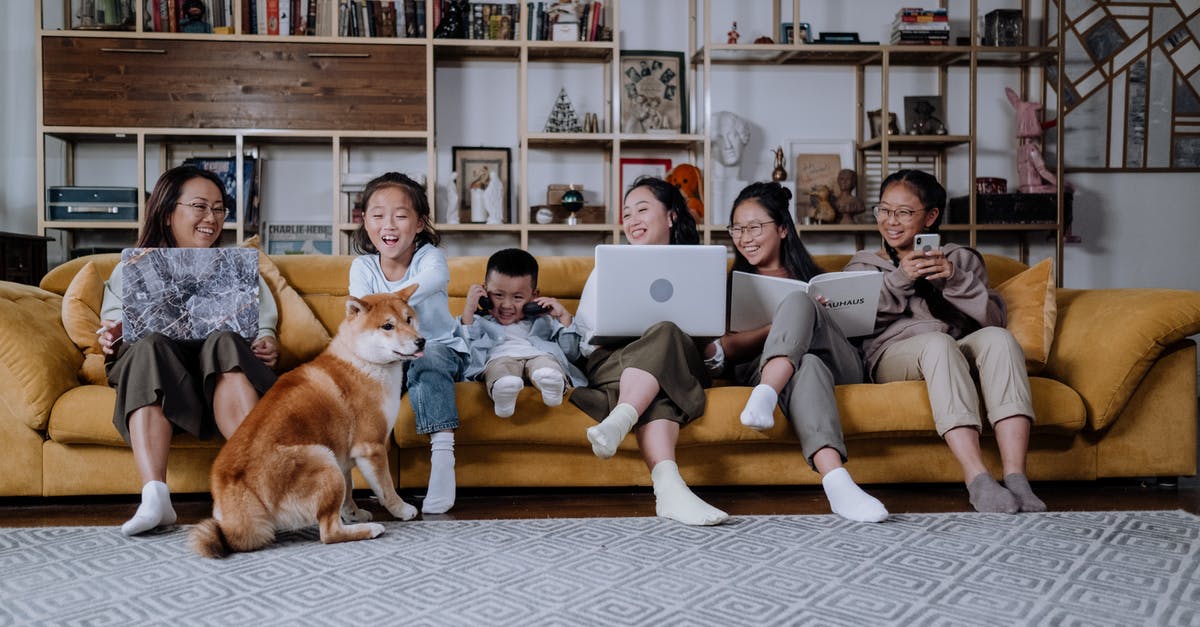 Why does my phone Micromax Canvas Spark reboot while playing Pokemon Go? [duplicate] - A Happy Family Sitting on the Couch while Playing with their Dog