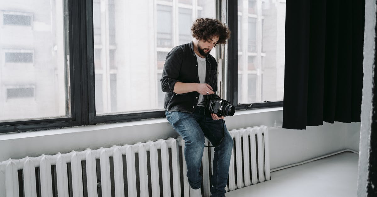 Why does the camera randomly go into the Skell? - Man in Black T-shirt and Blue Denim Jeans Sitting on White Wooden Fence