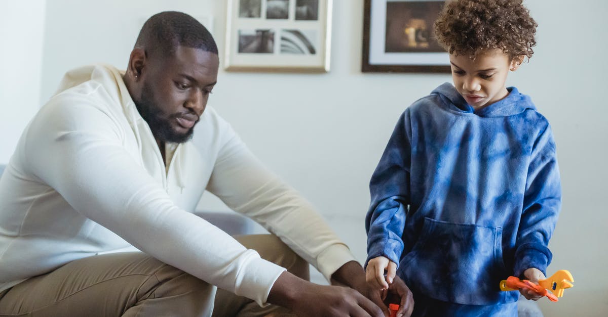 Why does the original Game Boy support four shades of grey? [closed] - Serious African American father helping curly haired son during game with toy instruments at home