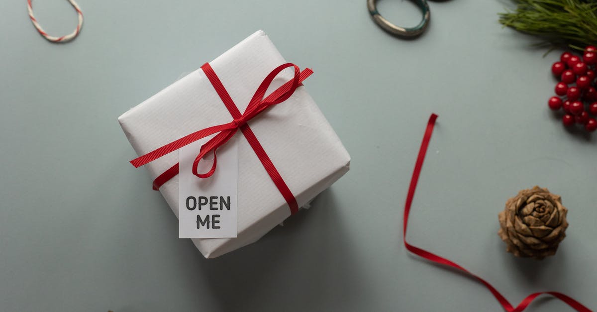 Why does Voorhees call me "china"? - Top view of present box with Open Me inscription on tag and ribbon bow near pine cones on light background