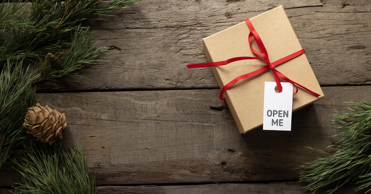 Why does Voorhees call me "china"? - Top view of present cardboard box with ribbon and Open Me title on tag near spruce sprigs on wooden surface during New Year holiday